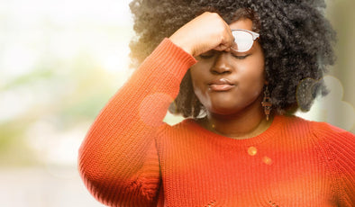 African American woman suffering from eye strain from sunlight